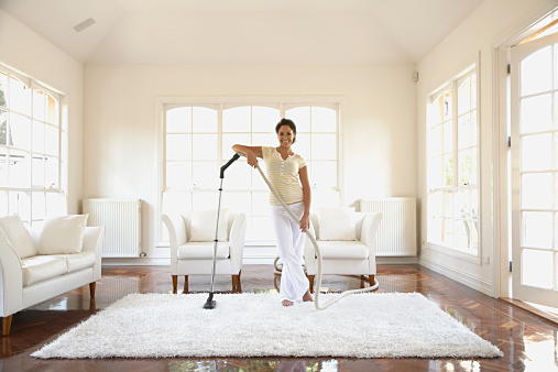 Hispanic woman vacuuming floor