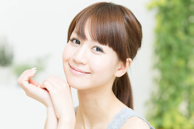 頬杖をつきこちらを見る笑顔の女性