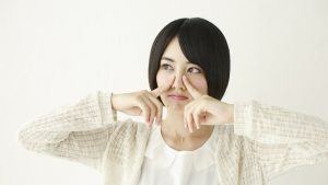 指で小鼻を強く押す