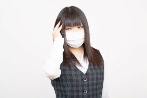 花粉症と風邪で頭痛に苦しめられる女性