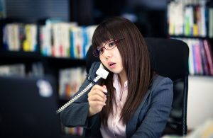 オフィスで電話対応中の女性