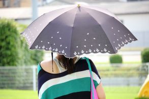 晴雨兼用傘をさす女性
