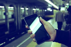駅でiPhone6sPlusを見る男性