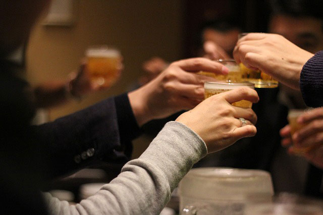 「かんぱ~い!」グラスを合わせて乾杯する人々