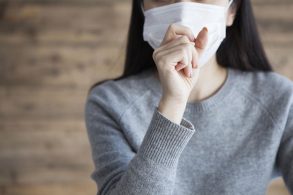 咳をするマスク姿の女性
