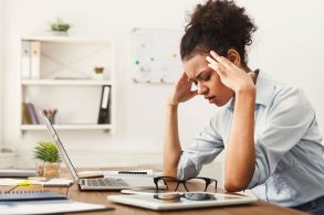 PCの前で頭を抱える女性