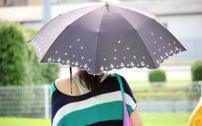 晴雨兼用傘をさす女性