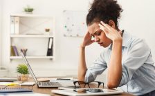 PCの前で頭を抱える女性